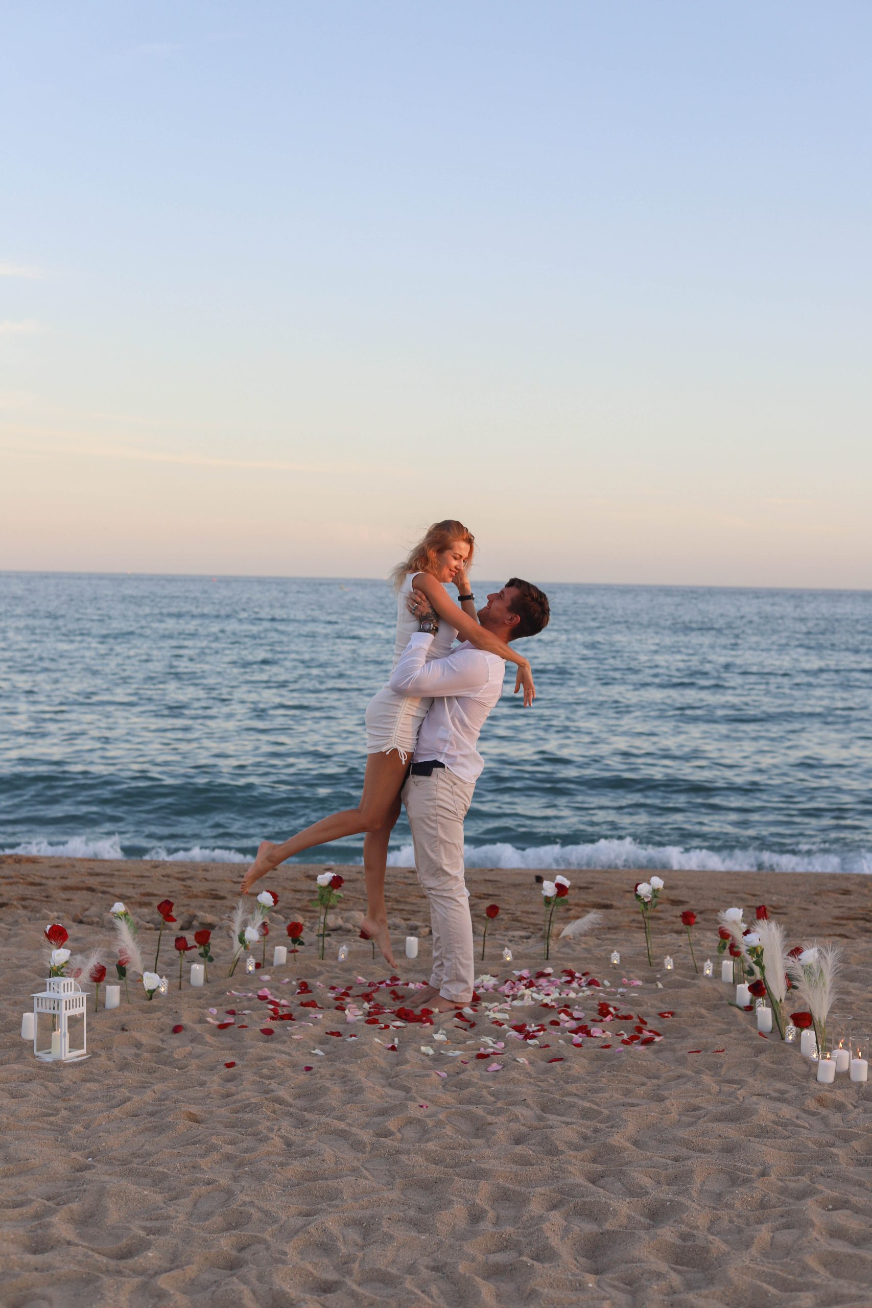 Couple laughing on the beach after proposal