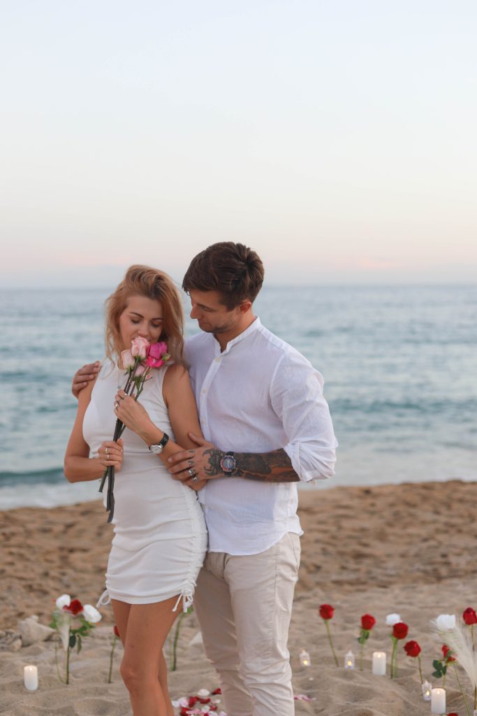 an kneeling on the sand proposing at sunset, Barcelona beach”