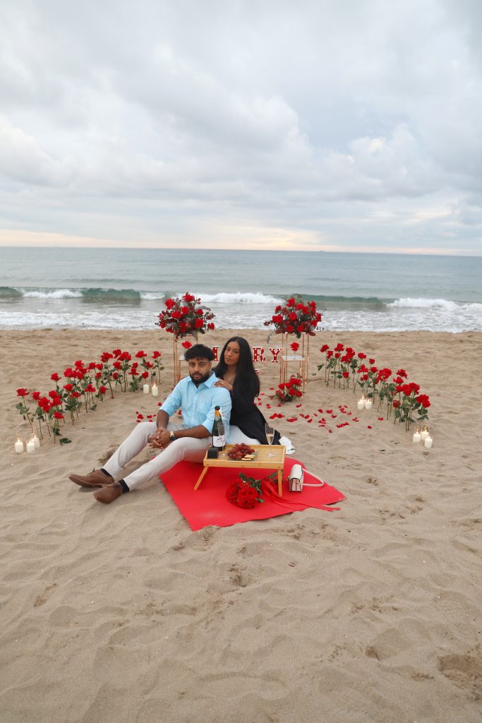 Beach proposal Barcelona with romantic setup at sunset