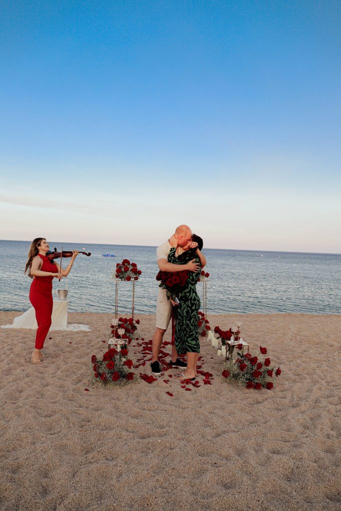 Romantic beach proposal decoration with flowers and candles in Costa Brava