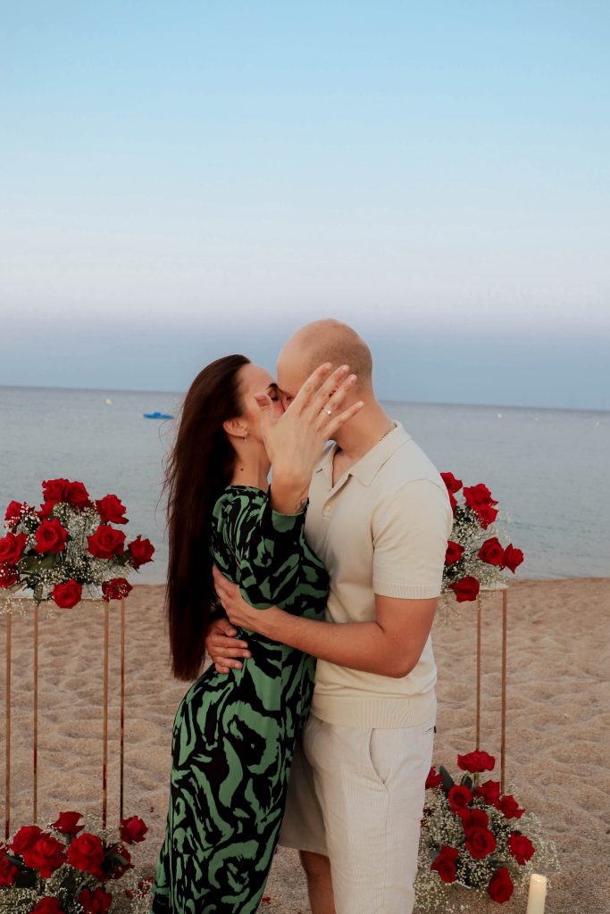 legant beach proposal setup in Costa Brava with fresh flowers, candles and romantic details prepared for a surprise marriage proposal.